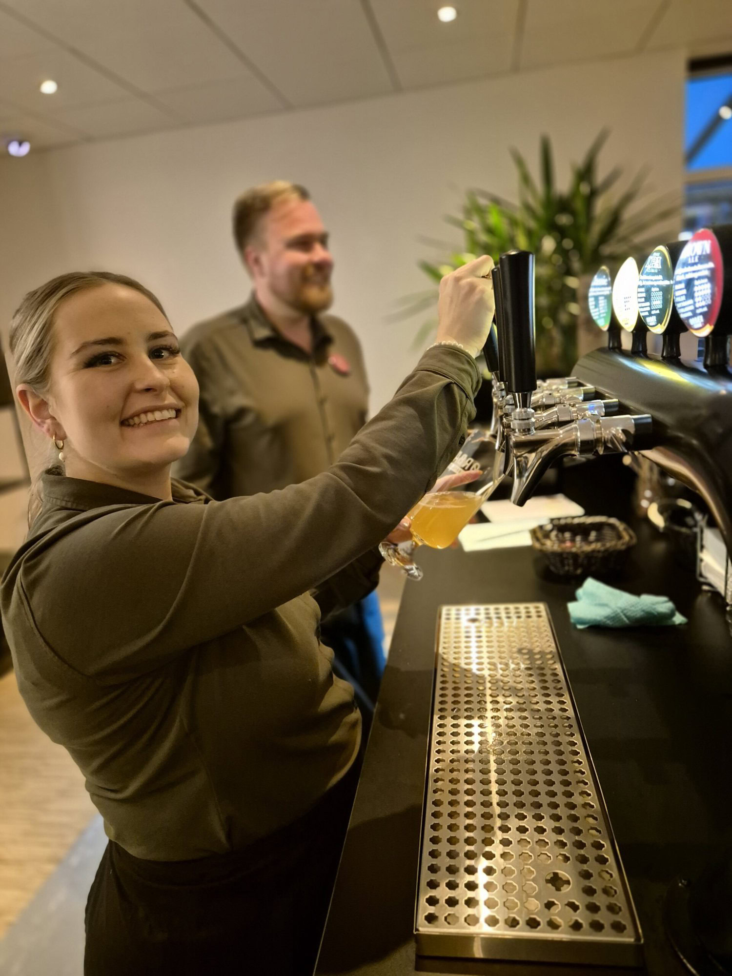 Tjenere Glenn og Laura skænker fadøl til julefrokost på Severin Kursuscenter og Hotel i Middelfart på Fyn