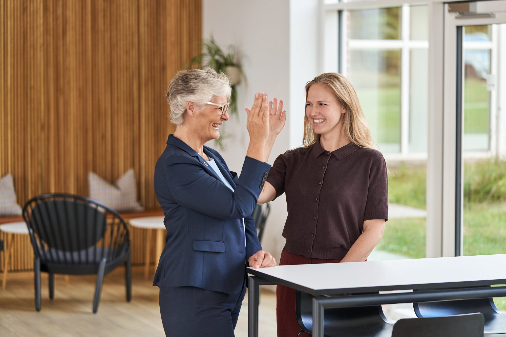 Konferencekoordinator Lisbeth giver gæst en highfive på Severin Kursuscenter og Hotel i Middelfart på Fyn