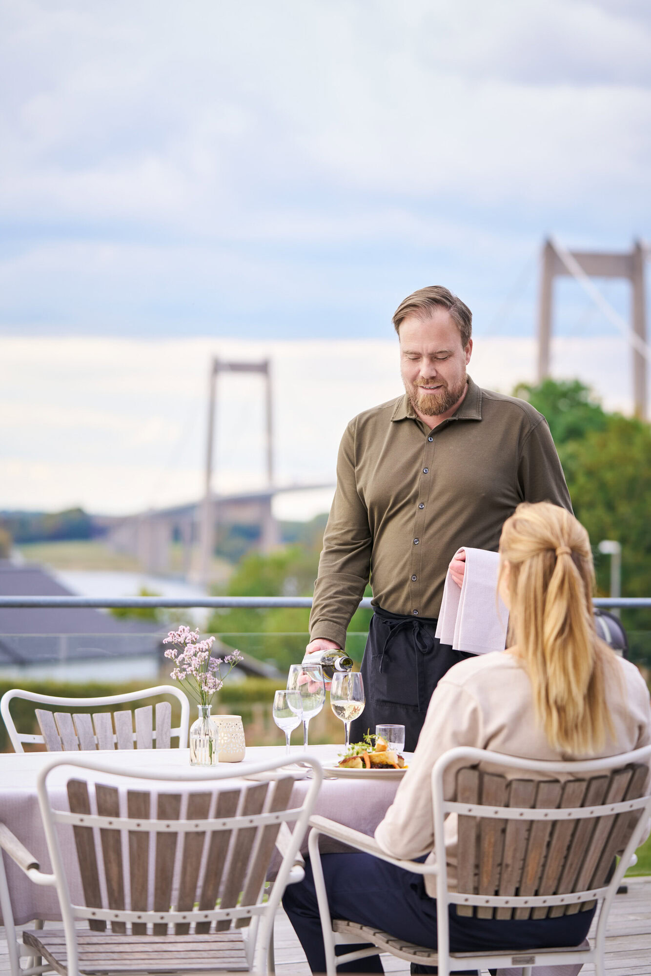 Tjenerelev Glenn serverer mad på terrassen til en gæst på Severin Kursuscenter og Hotel i Middelfart på Fyn